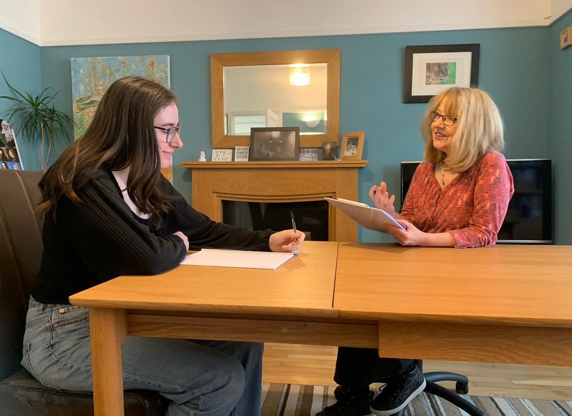 Christine talking with a parent at the table